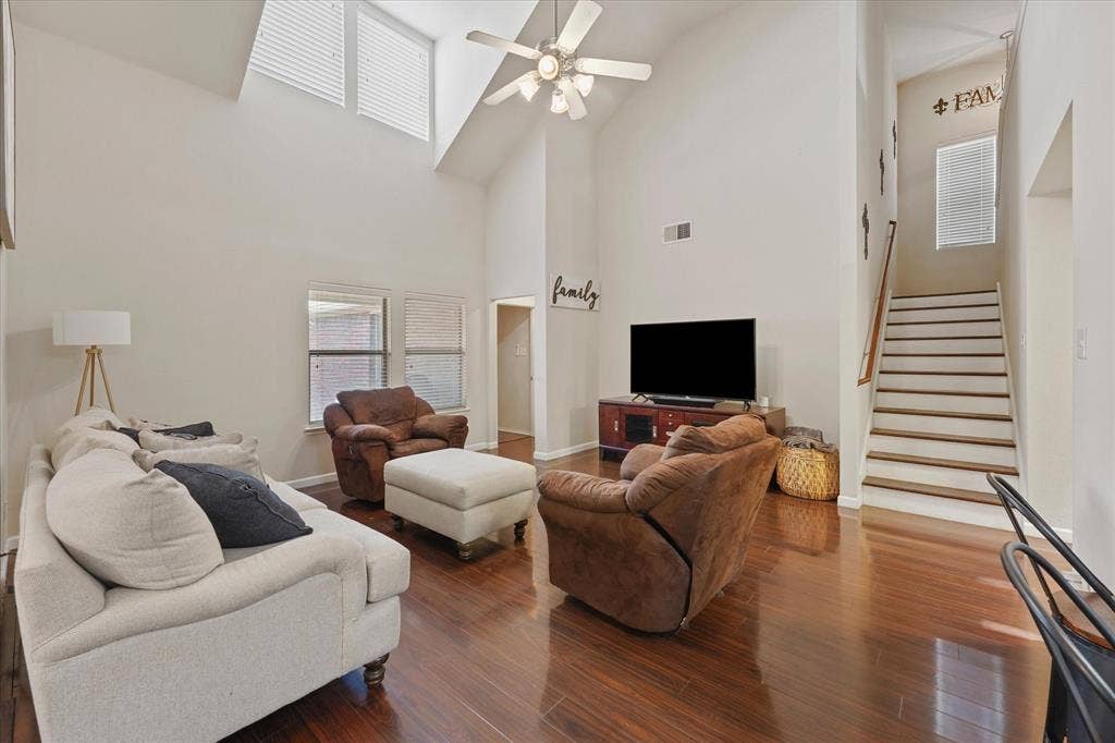 2053 Lake Trail Drive, Heartland, TX 75126 Vaulted ceiling with a ceiling fan, recessed windows, wood-finish flooring, and a staircase with wood treads