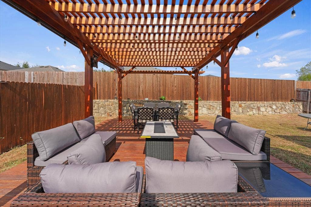 2053 Lake Trail Drive, Heartland, TX 75126 Outdoor living area featuring a wooden pergola, wood-finish deck, and stone retaining wall