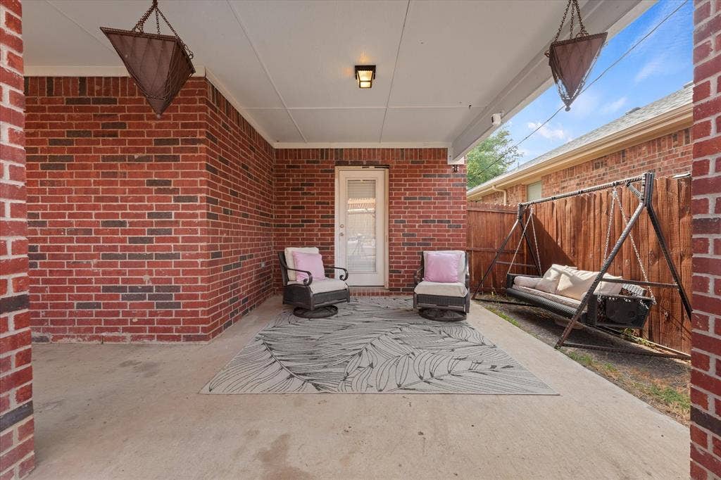2053 Lake Trail Drive, Heartland, TX 75126 Covered concrete patio featuring brick exterior walls and a privacy fence