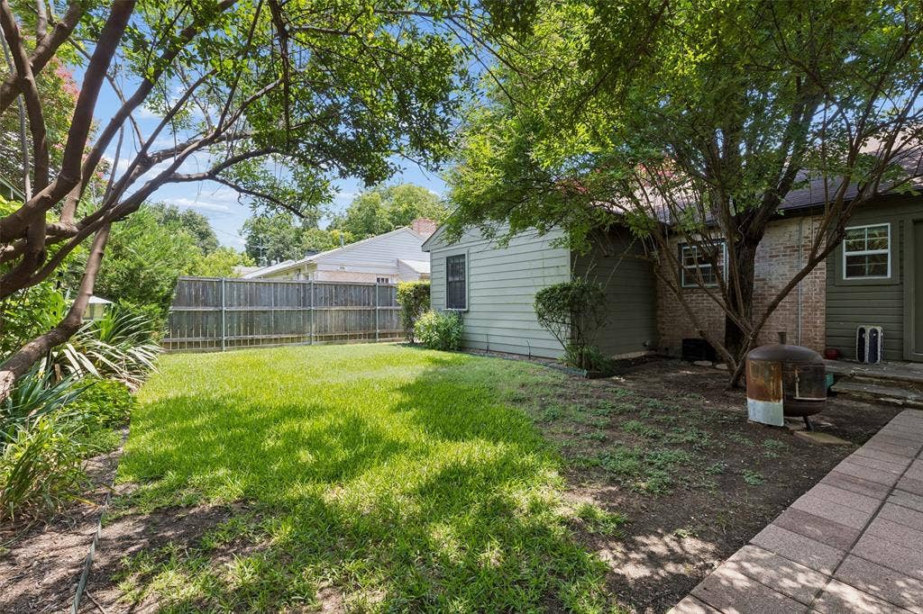 Expansive grassy area with mature trees providing coverage