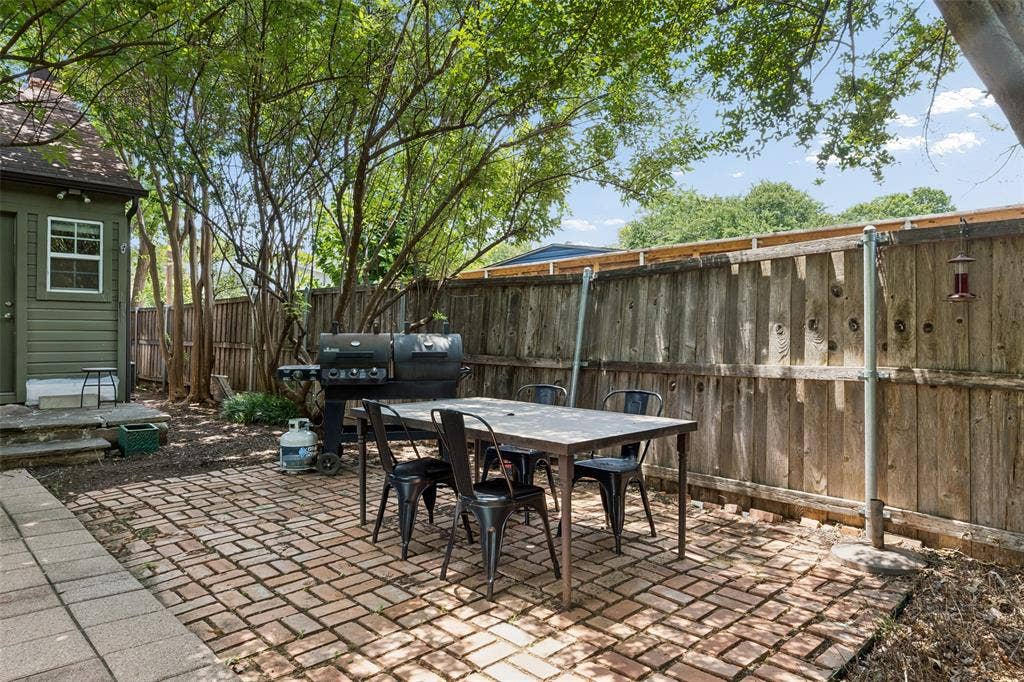 Brick paver patio with a wood privacy fence