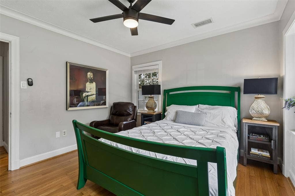 Hardwood flooring, crown molding, ceiling fan with integrated lighting, natural light through window, neutral wall palette