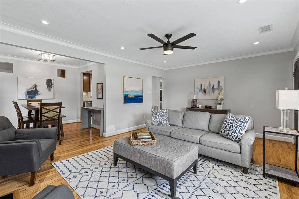 Hardwood flooring, recessed lighting, crown molding, a ceiling fan, and a contemporary dining light fixture
