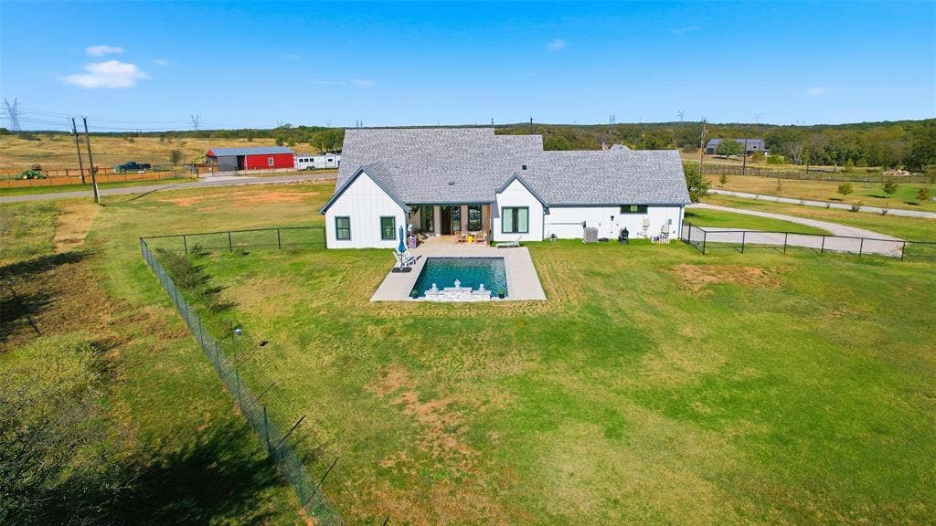 Rear view of house with a patio area, a fenced backyard, and a view of countryside