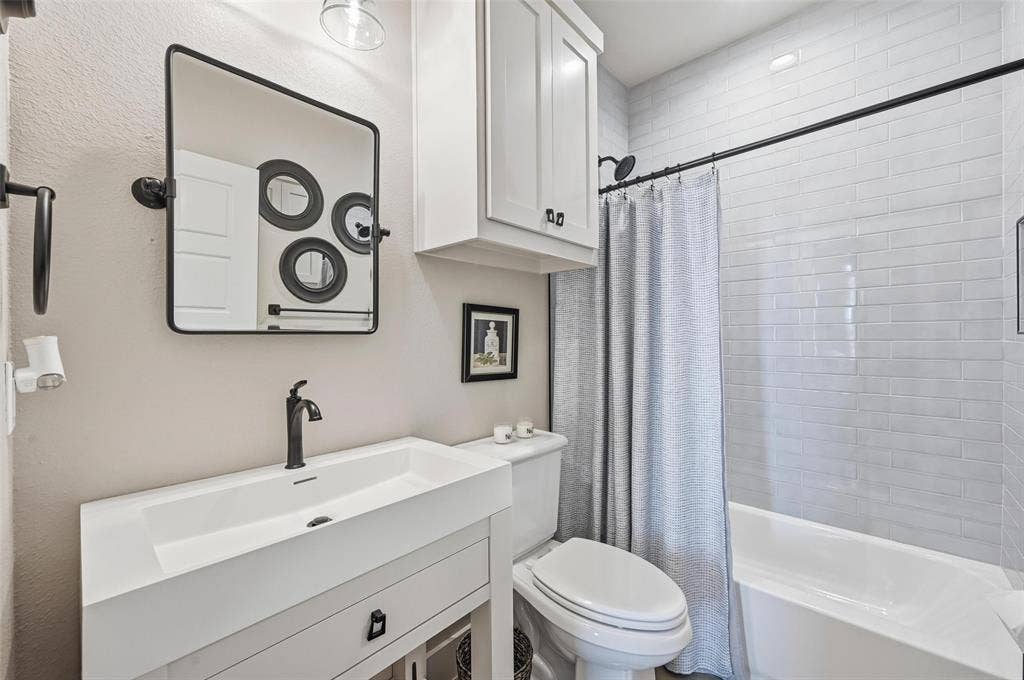 Bathroom with shower / tub combo with curtain and vanity