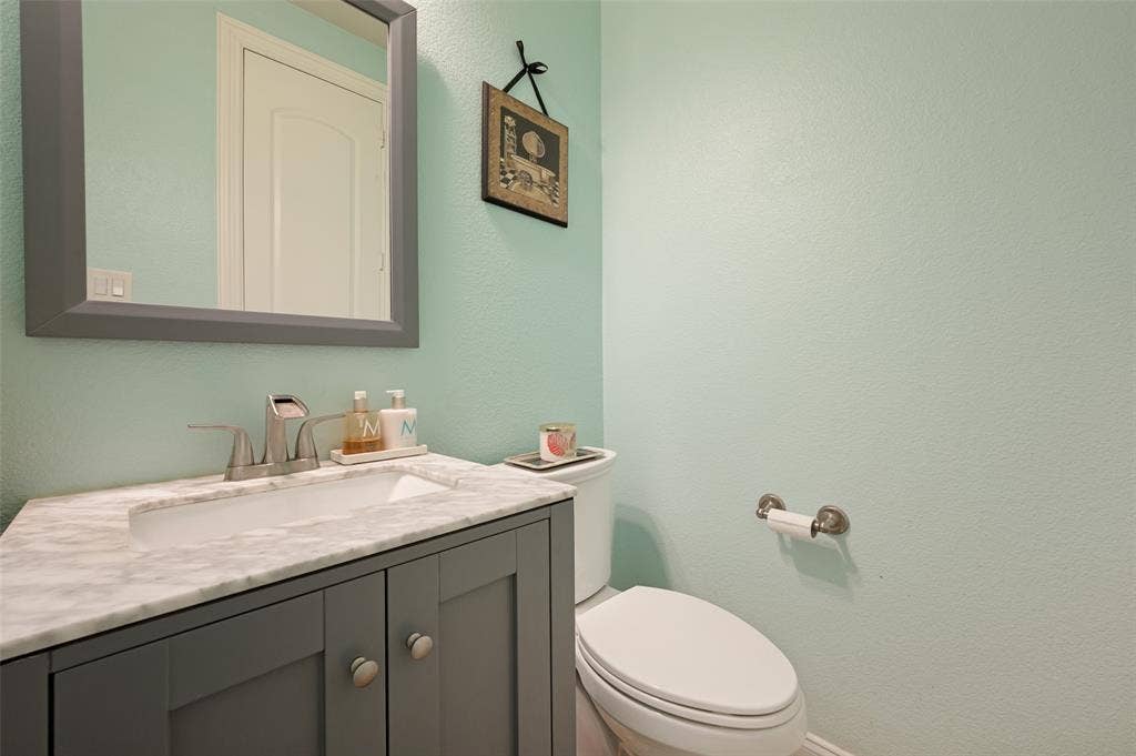 741 Darian Drive, Prosper, TX 75078 Vanity with panel-front cabinetry, integrated rectangular sink, and stone-finish countertop