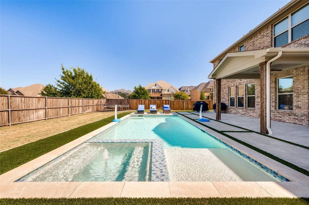 741 Darian Drive, Prosper, TX 75078 Contemporary swimming pool with integrated spa, concrete patio, covered outdoor living area, and a brick exterior