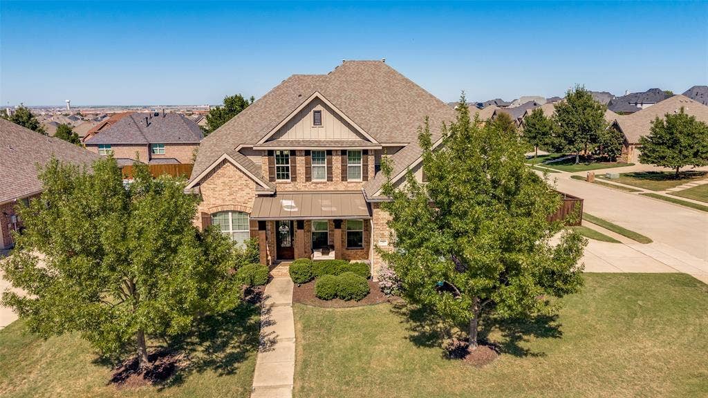 741 Darian Drive, Prosper, TX 75078 Brick and siding exterior with dark shutters, covered front entry, established landscaping, and an attached garage