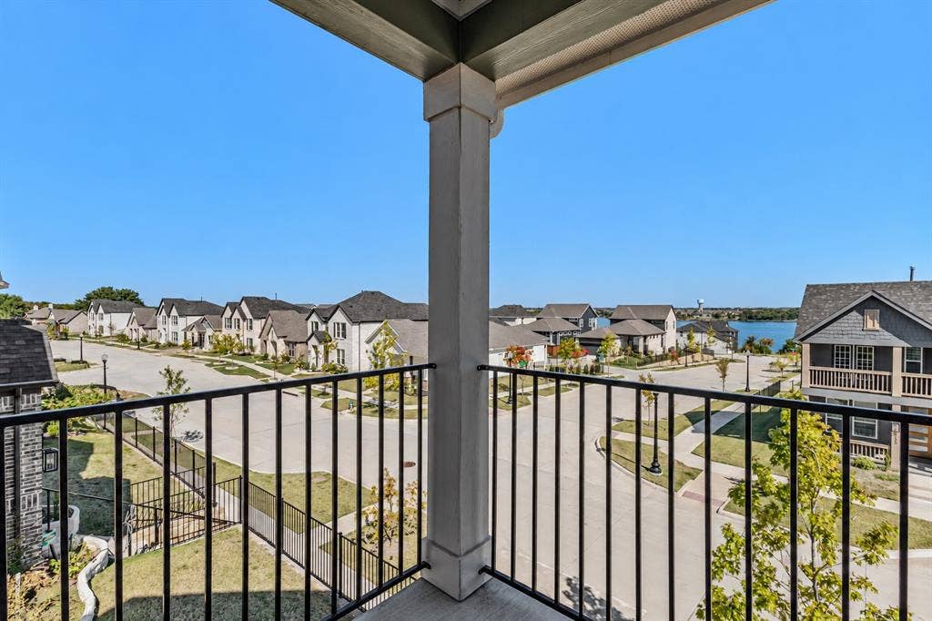 2601 Lafayette Drive, Rowlett, TX 75088 Balcony with a black metal railing and a concrete floor, offering neighborhood scenery and a distant body of water