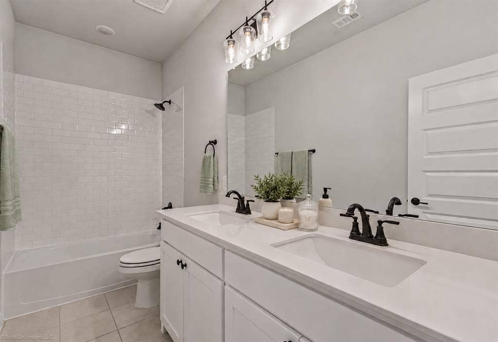 2601 Lafayette Drive, Rowlett, TX 75088 Double vanity with integrated sinks and white countertops, matte black faucets, and a three-light fixture