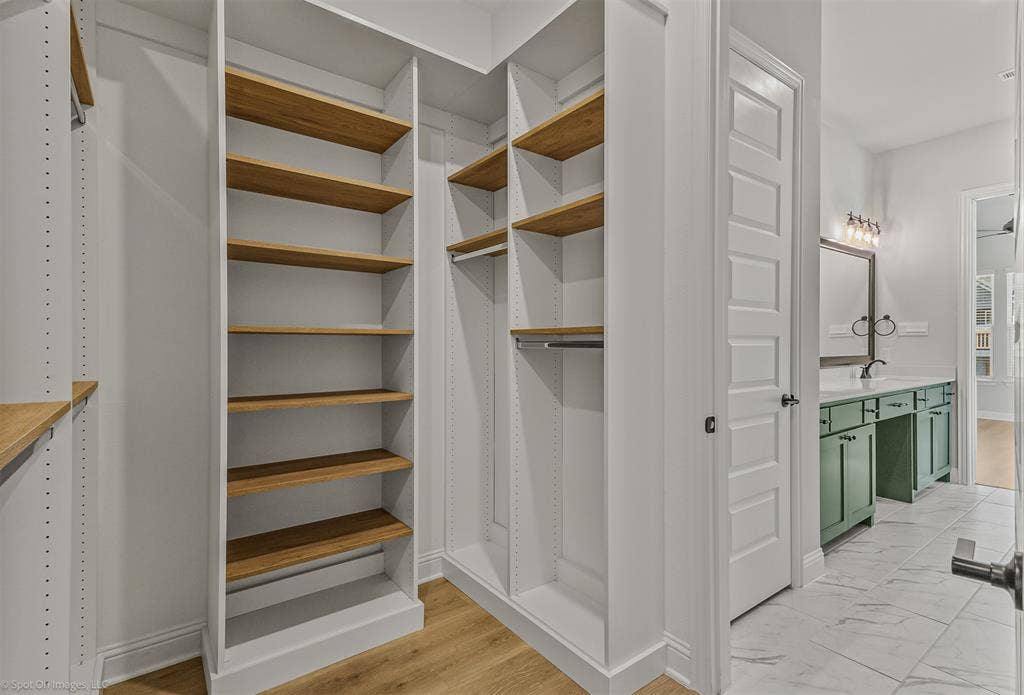 2601 Lafayette Drive, Rowlett, TX 75088 Built-in closet shelving with wood-finish shelves, hanging rods, and wood-finish flooring