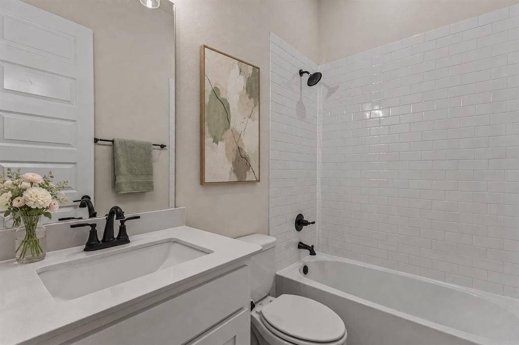 2601 Lafayette Drive, Rowlett, TX 75088 Bathroom featuring a white vanity with an integrated sink, matte black faucet, and a large mirror