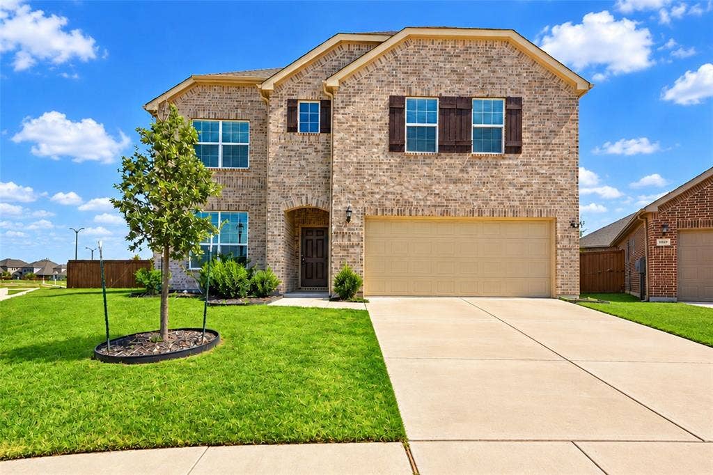 1805 Nelson Street, Anna, TX 75409 Brick exterior with wood shutters, concrete driveway, and attached garage