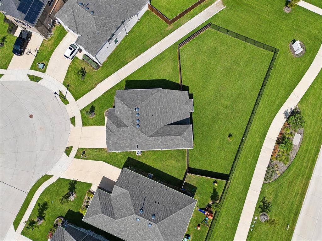1805 Nelson Street, Anna, TX 75409 Expansive grassy yard with perimeter fencing, concrete pathways, and surrounding residential structures