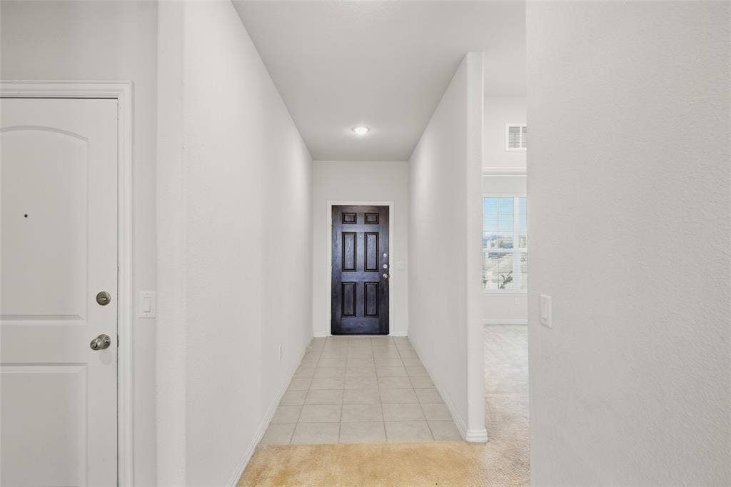 1805 Nelson Street, Anna, TX 75409 Recessed lighting illuminates the tiled entry hallway with a paneled dark wood-finish door