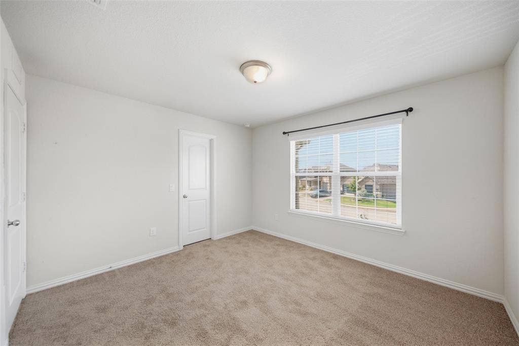 1805 Nelson Street, Anna, TX 75409 Carpeted room with white walls, a large window with blinds, and white doors