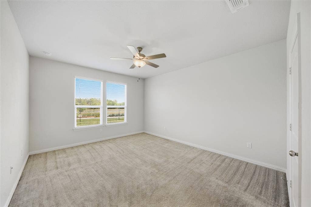 1805 Nelson Street, Anna, TX 75409 Recessed lighting, ceiling fan with light fixture, two windows with blinds, and light gray carpeting