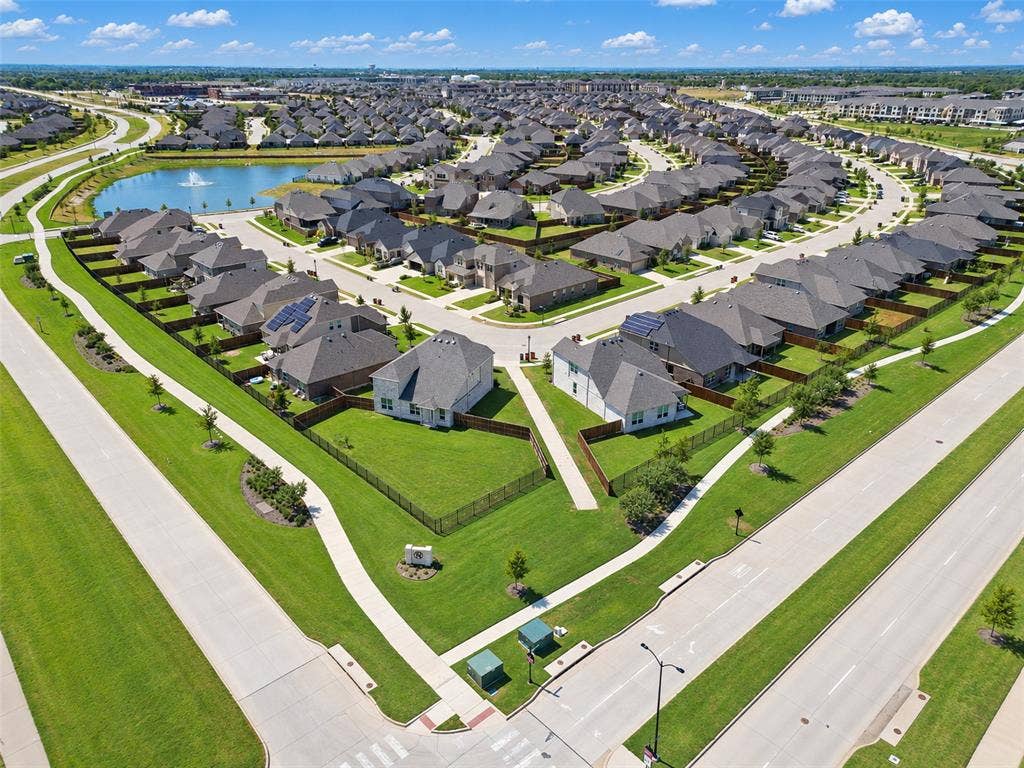1805 Nelson Street, Anna, TX 75409 Residential community with a curving street layout, a central pond, and multiple properties featuring green lawns
