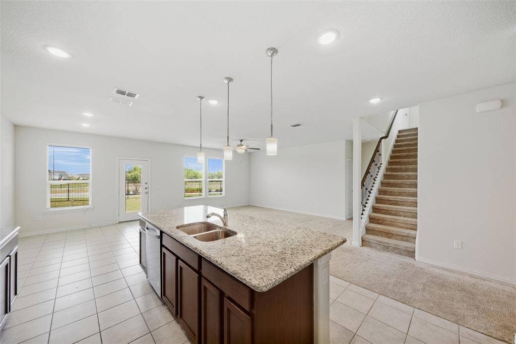 1805 Nelson Street, Anna, TX 75409 Kitchen island with integrated double sink, granite-style countertop, and pendant lighting