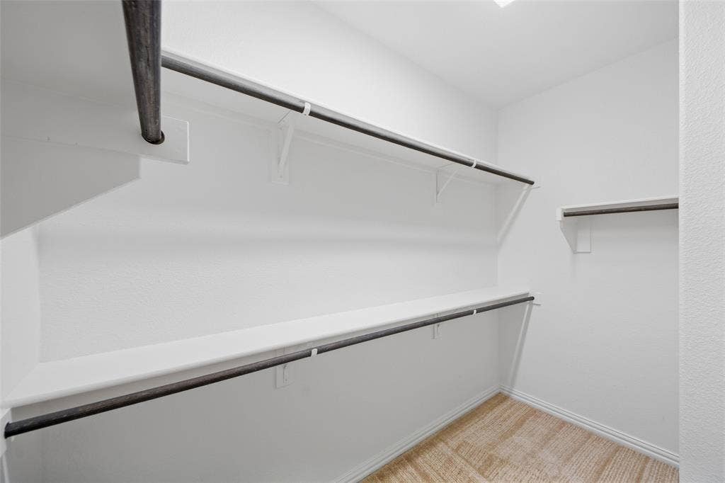 1805 Nelson Street, Anna, TX 75409 Walk-in closet with multiple hanging rods, shelving, white walls, and wood-finish flooring