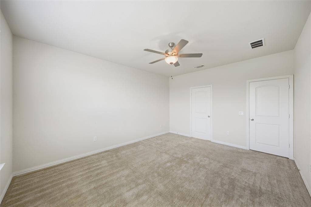 1805 Nelson Street, Anna, TX 75409 Spacious room featuring neutral carpeting, a ceiling fan with integrated lighting, and two panel doors