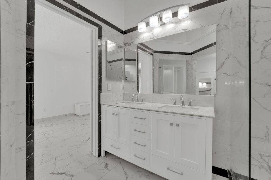 Dual vanity with undermount sinks, chrome fixtures, and white cabinetry