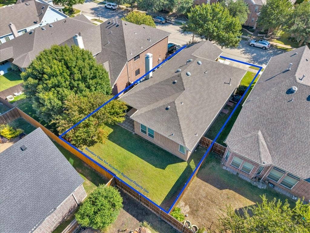 5612 Hampshire Drive, McKinney, TX 75070 Rear exterior with a pitched roof, brick siding, and a grass lawn