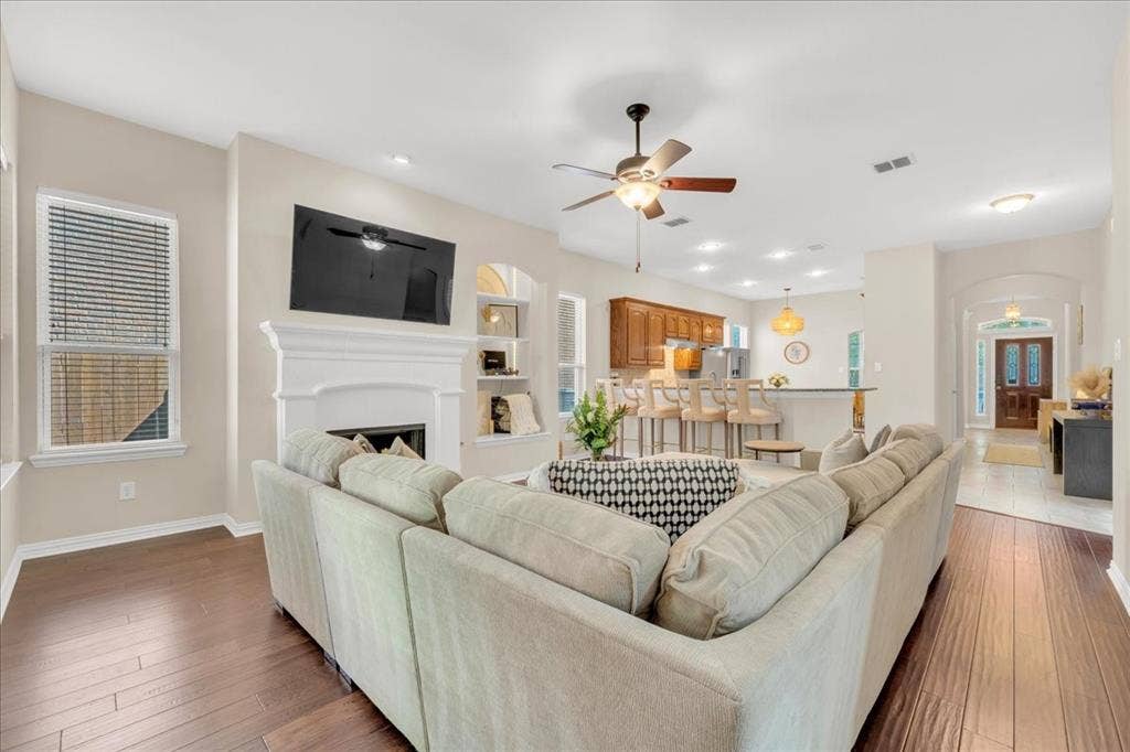 5612 Hampshire Drive, McKinney, TX 75070 Wood-finish flooring throughout, with a classic white mantel fireplace and built-in shelving