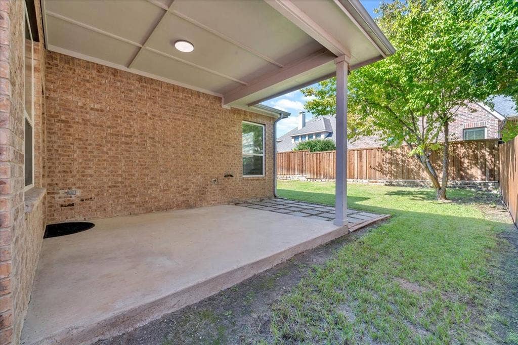 5612 Hampshire Drive, McKinney, TX 75070 Covered concrete patio with a recessed light, brick exterior, and a manicured lawn
