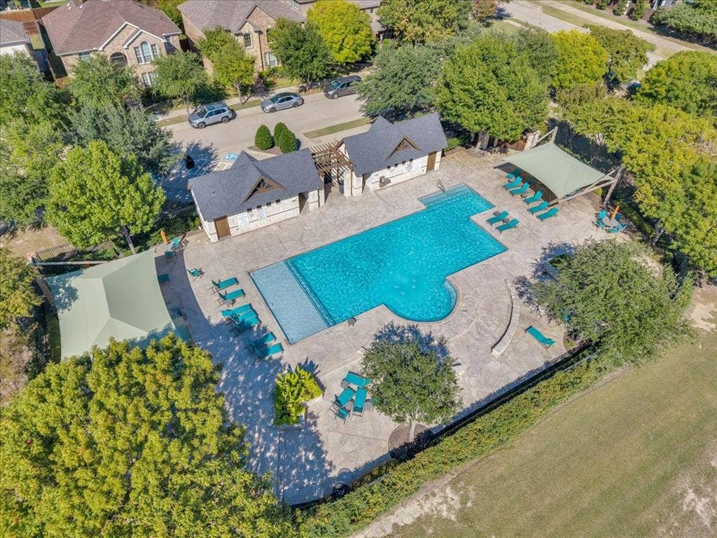 5612 Hampshire Drive, McKinney, TX 75070 Community swimming pool with an integrated spa, surrounded by a concrete deck, and two shade structures