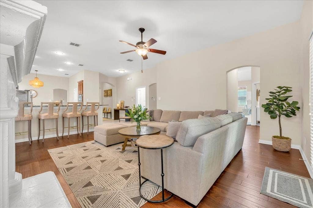 5612 Hampshire Drive, McKinney, TX 75070 Hardwood-finish flooring, recessed lighting, and a ceiling fan are featured in this open-concept room with arched doorways