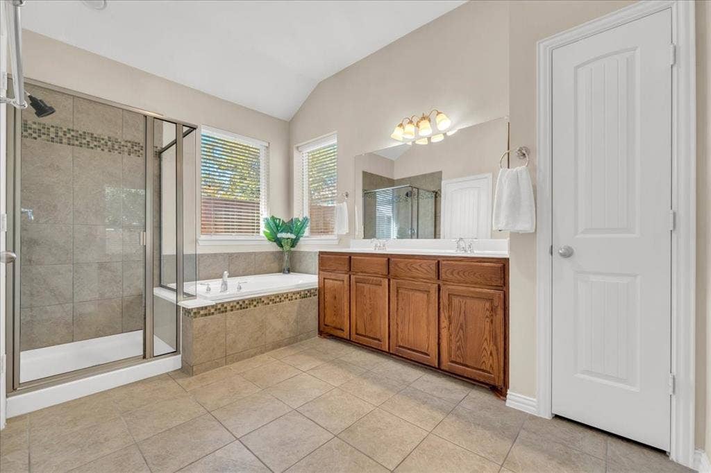5612 Hampshire Drive, McKinney, TX 75070 Spacious bathroom featuring a glass-enclosed shower, a separate soaking tub, dual vanity with wood cabinetry, and tiled flooring