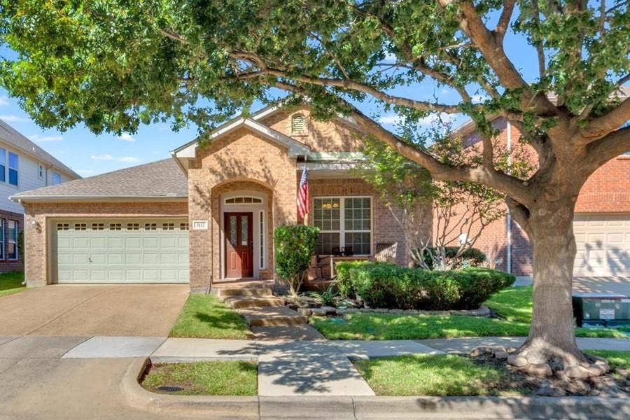5612 Hampshire Drive, McKinney, TX 75070 Brick exterior with a prominent arched entry, two-car garage, and a concrete driveway