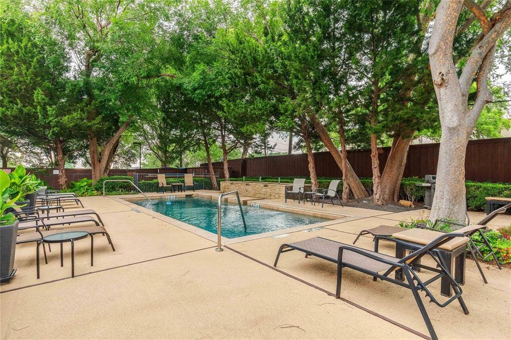 4605 Cedar Springs Road, #327, Dallas, TX 75219 Outdoor swimming pool featuring a perimeter of mature trees and a surrounding hardscape deck