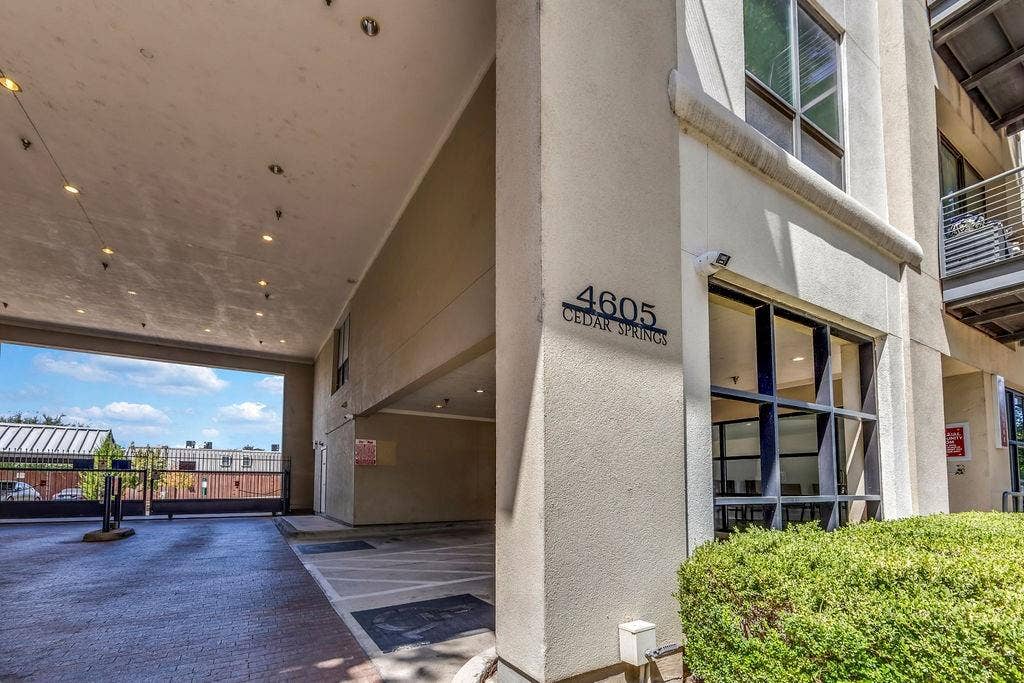 4605 Cedar Springs Road, #327, Dallas, TX 75219 Covered parking entry featuring a wrought iron gate and brick paver flooring