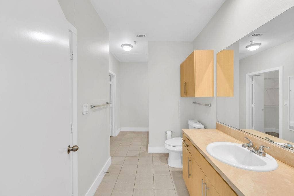 4605 Cedar Springs Road, #327, Dallas, TX 75219 Full-length vanity mirror, ample wood-finish cabinetry, tile flooring, and recessed lighting