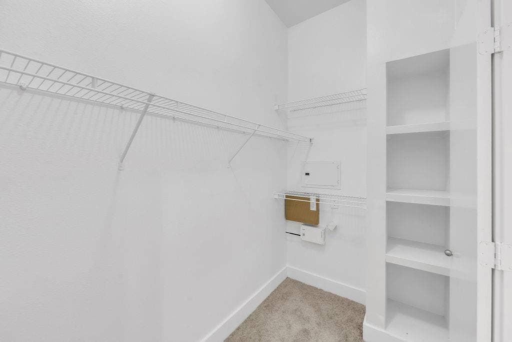 4605 Cedar Springs Road, #327, Dallas, TX 75219 White wire shelving, built-in shelving unit, white walls, and carpet flooring