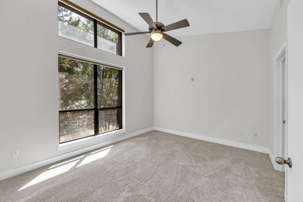 4605 Cedar Springs Road, #327, Dallas, TX 75219 Vaulted ceiling, oversized windows, additional transom windows, ceiling fan, and light-toned carpeting