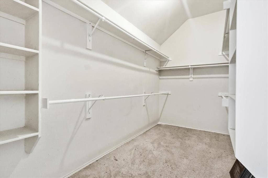 Built-in shelving, multiple hanging rods, and an angled ceiling