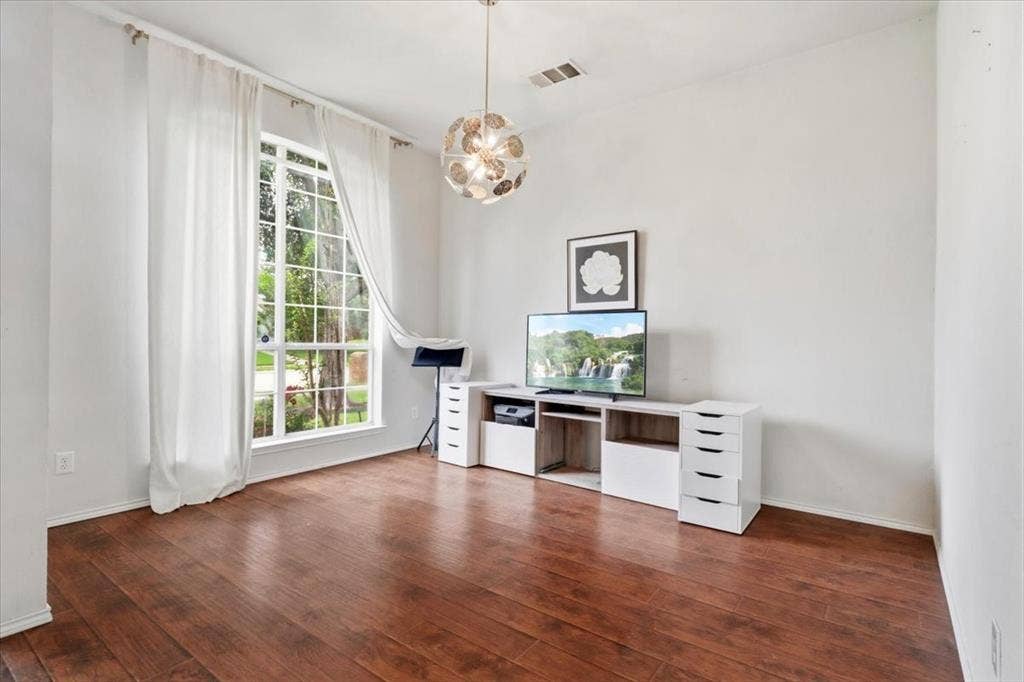 Wood-finish flooring, large multi-pane window, and a spherical pendant light fixture