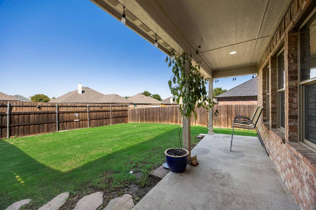 221 Cliffbrook Drive, Wylie, TX 75098 Expansive concrete patio with recessed lighting and string lights, providing outdoor living space