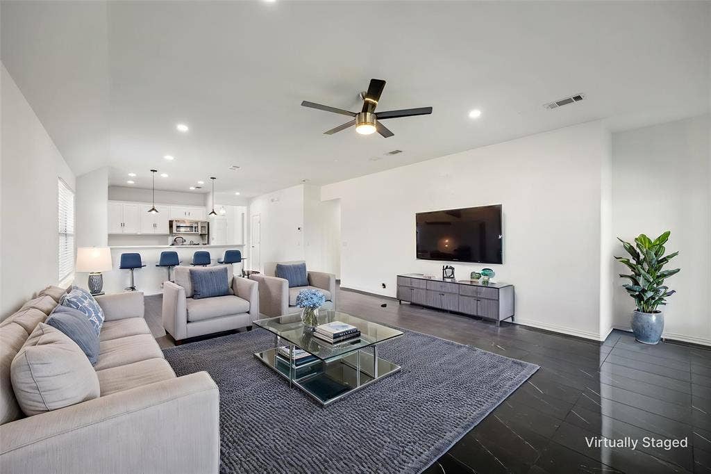 221 Cliffbrook Drive, Wylie, TX 75098 Open-concept living space featuring high ceilings, dark wood-finish flooring, recessed lighting, and a contemporary ceiling fan