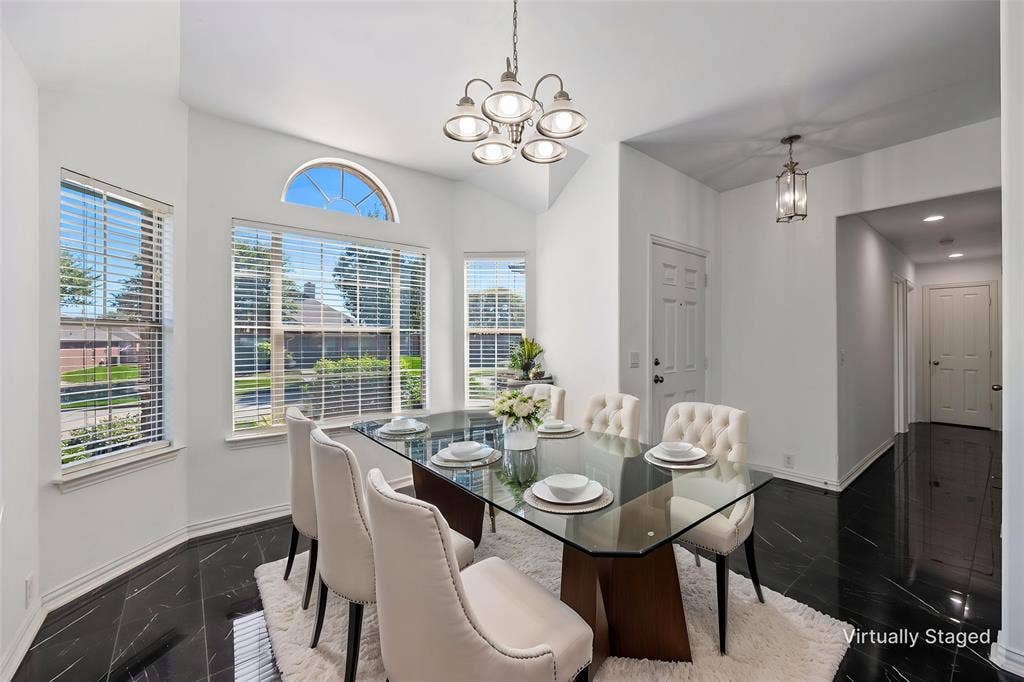 221 Cliffbrook Drive, Wylie, TX 75098 Vaulted ceiling with a multi-light chandelier, arched transom window, multiple windows with blinds, and black tile flooring