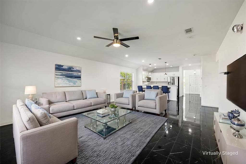 221 Cliffbrook Drive, Wylie, TX 75098 Open-concept living space featuring black tile flooring, white walls, and a ceiling fan with integrated lighting