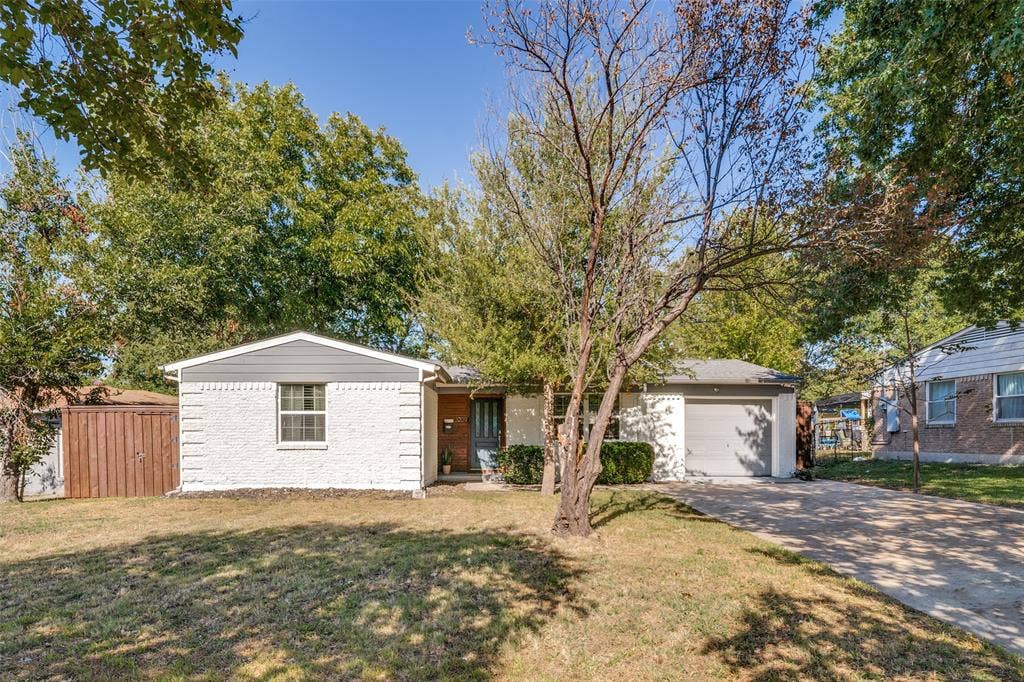 3209 Karla Drive, Mesquite, TX 75150 White painted brick exterior with gray siding and a gray garage door