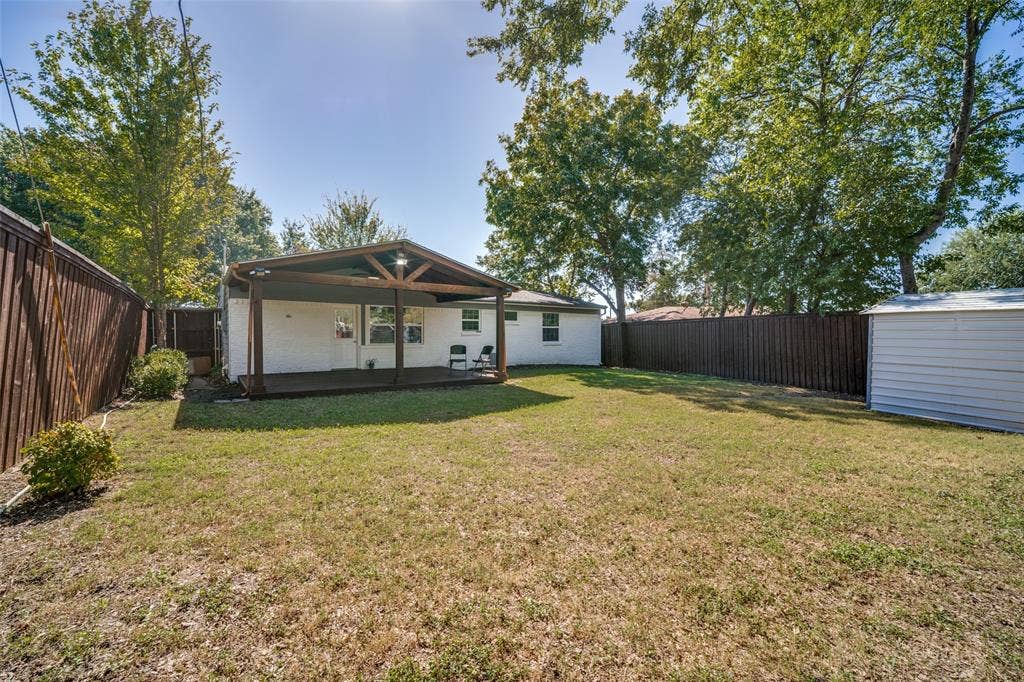 3209 Karla Drive, Mesquite, TX 75150 White brick exterior with a wood-paneled entry