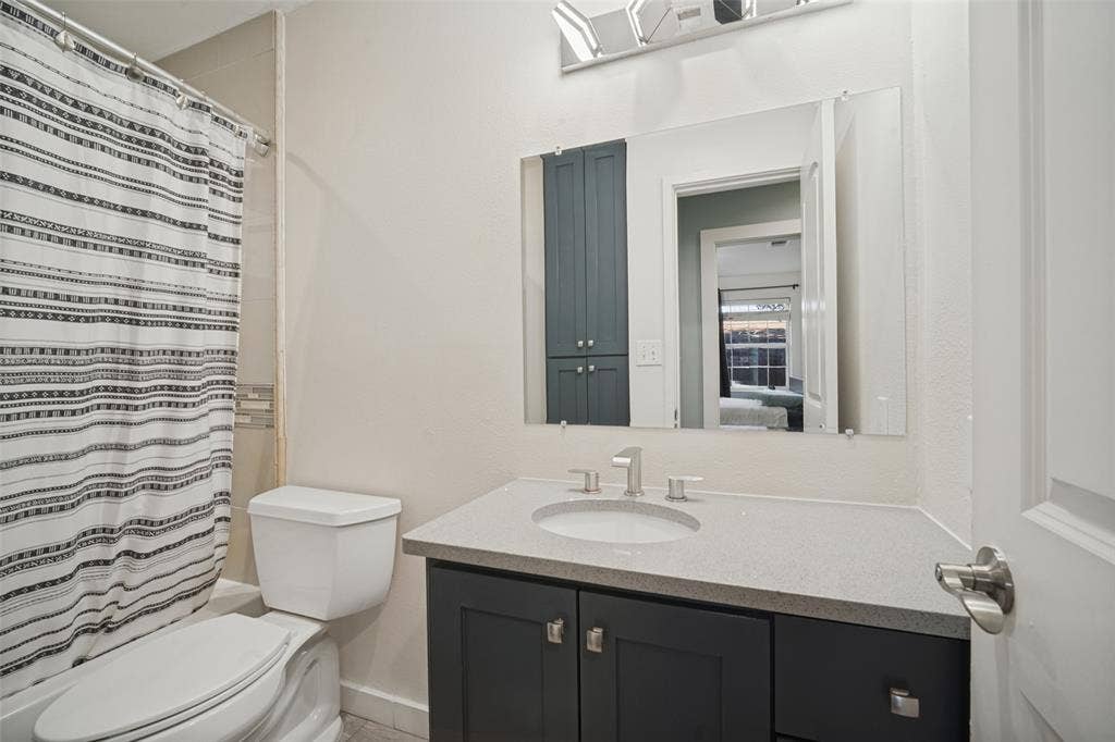 3209 Karla Drive, Mesquite, TX 75150 Vanity with a light-toned countertop, under-mount sink, and dark cabinetry