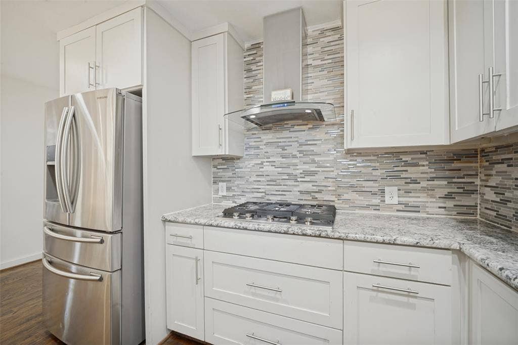 3209 Karla Drive, Mesquite, TX 75150 White shaker-style cabinetry with chrome hardware, stone countertops, gas range, and a mosaic tile backsplash