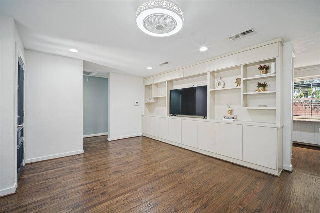 3209 Karla Drive, Mesquite, TX 75150 Wood-finish flooring, white walls, and a built-in entertainment center with integrated shelving