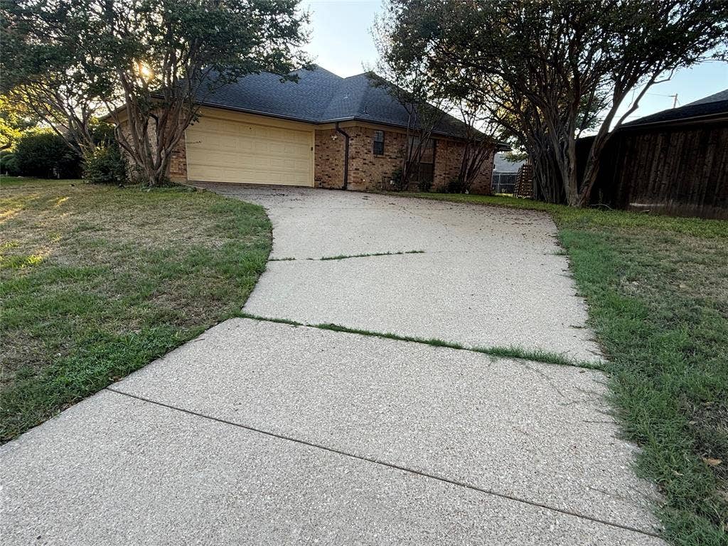 3407 Ruidoso Drive, Arlington, TX 76017 Brick exterior with a prominent two-car garage, concrete driveway, and mature trees
